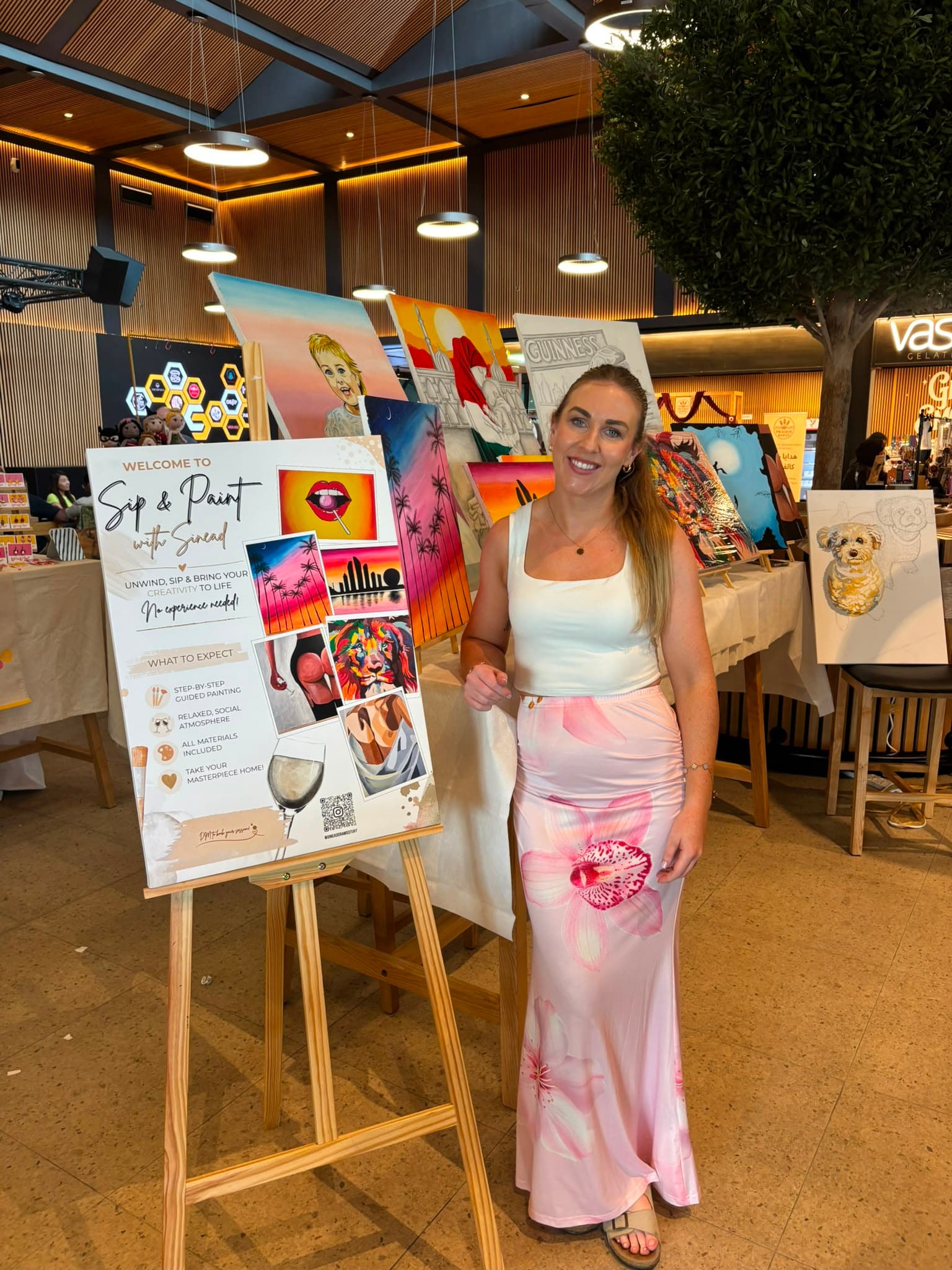 Sinead at a Sip and Paint event with her paintings