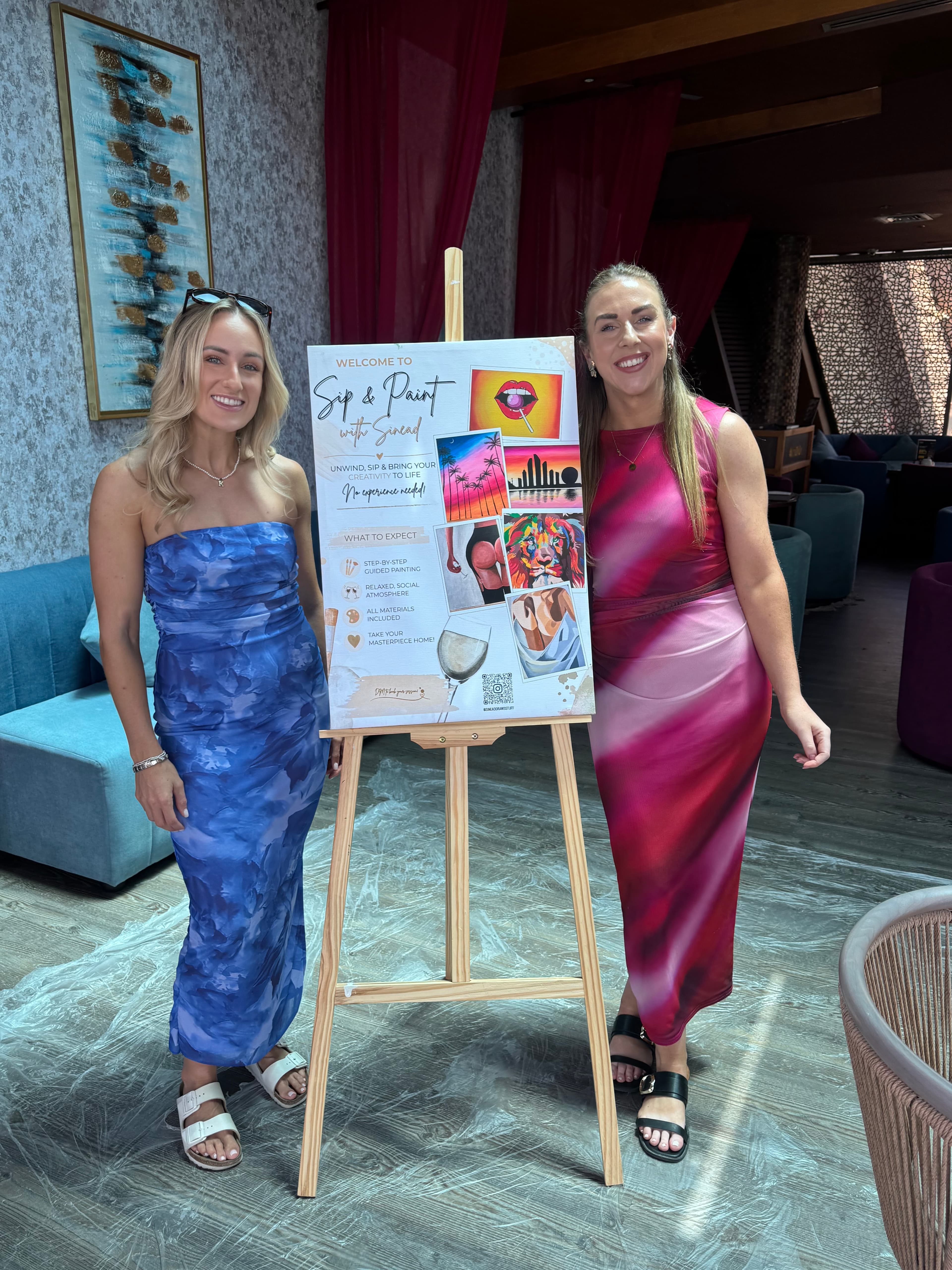 Two women with a Sip & Paint with Sinéad sign